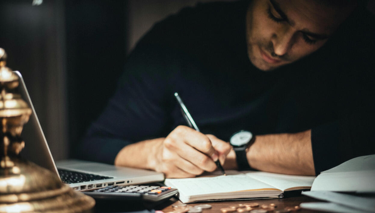 Entrepreneur en PME de services rédigeant manuellement devis et paiements